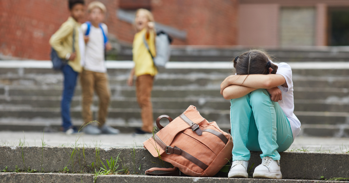 bully prevention, student with her head down on the steps.